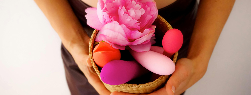 Bir kutu içinde seks oyuncakları tutan kadın elleri.