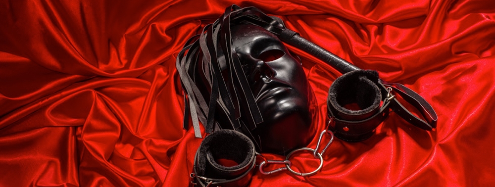 Kırmızı kumaş üzerinde BDSM ürünler fotoğrafı.